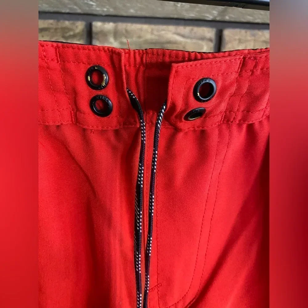 Red and black Nike swim trunks‎